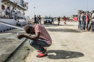 Refugee outside ship at dock in Greece