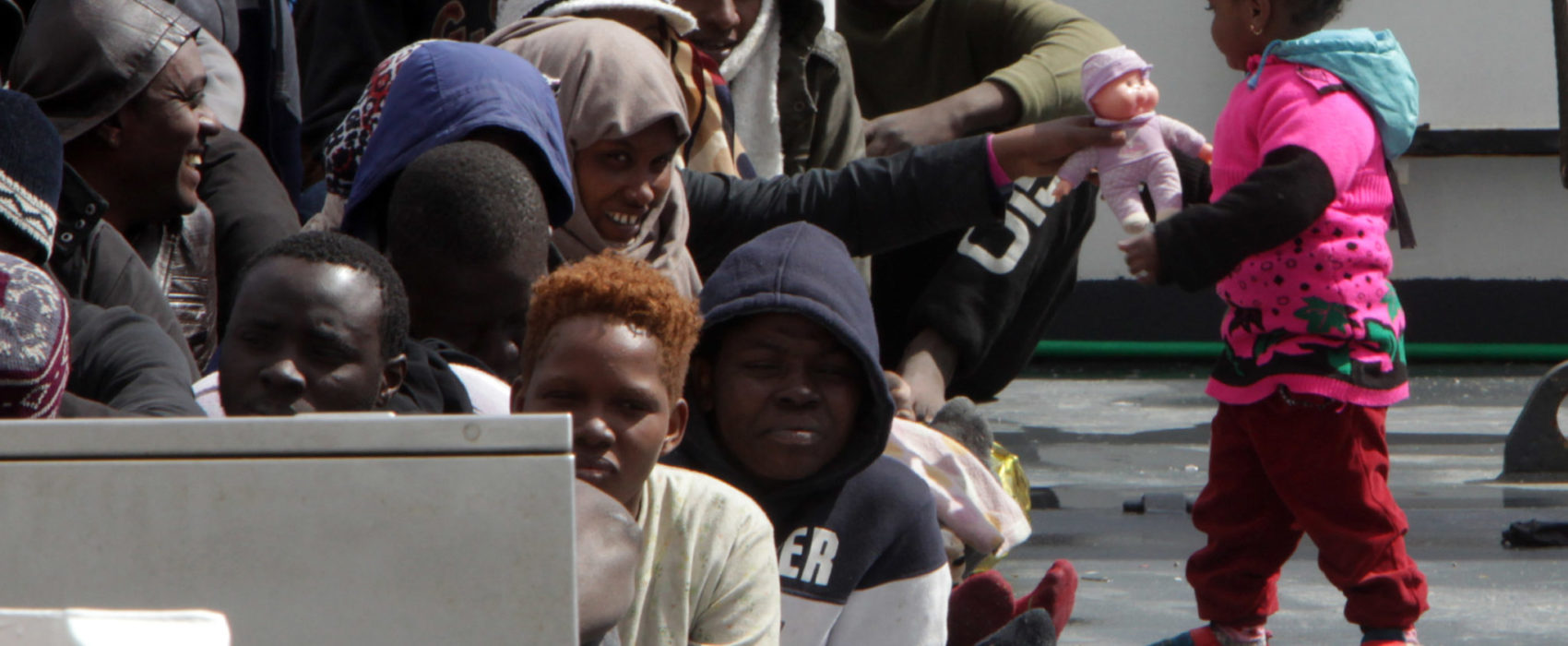 A little girl plays with a doll as migrants and refugees wait to disembark in the port of Messina following a rescue operation at sea by the Italian Coast Guard ship "Diciotti" on March 17, 2016 in Sicily. 
More than 2,400 migrants and three corpses have been recovered from people smugglers' boats off Libya Italy's coastguard said on March 16, 2016. After several quiet weeks, the figures represent a pick-up in the flow of migrants attempting to reach Italy via Libya, a route through which around 330,000 people have made it to Europe since the start of 2014. / AFP / GIOVANNI ISOLINO        (Photo credit should read GIOVANNI ISOLINO/AFP/Getty Images)