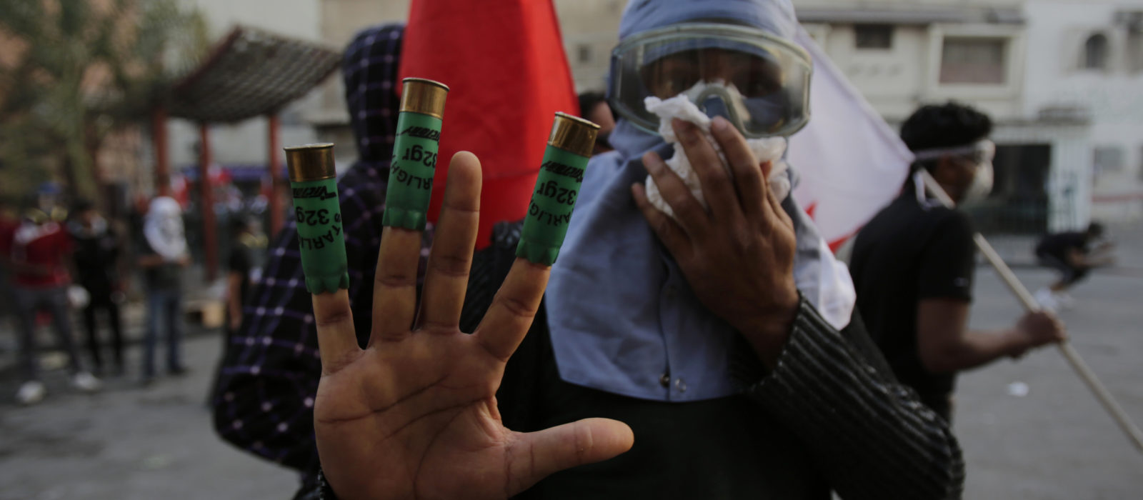 A Bahraini anti-government protester masked against tear gas show shotgun shells toward journalists during clashes between protesters throwing stones and riot police firing tear gas and shotguns in Bilad al-Qadeem, Bahrain, Friday, Jan. 16, 2015. Daily clashes have been escalating since the arrest of Shiite opposition leader Sheikh Ali Salman on Dec. 28. (AP Photo/Hasan Jamali)