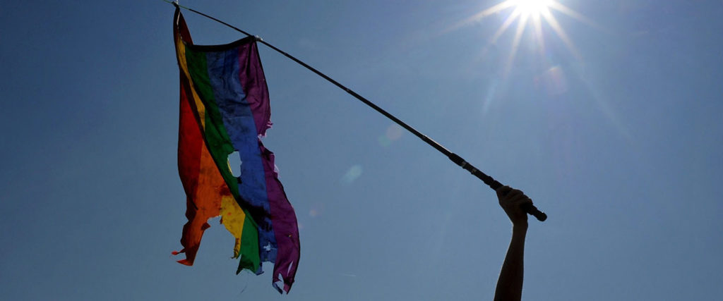 Gay rights activist waves a damaged rainbow flag during a gay pride in Russia