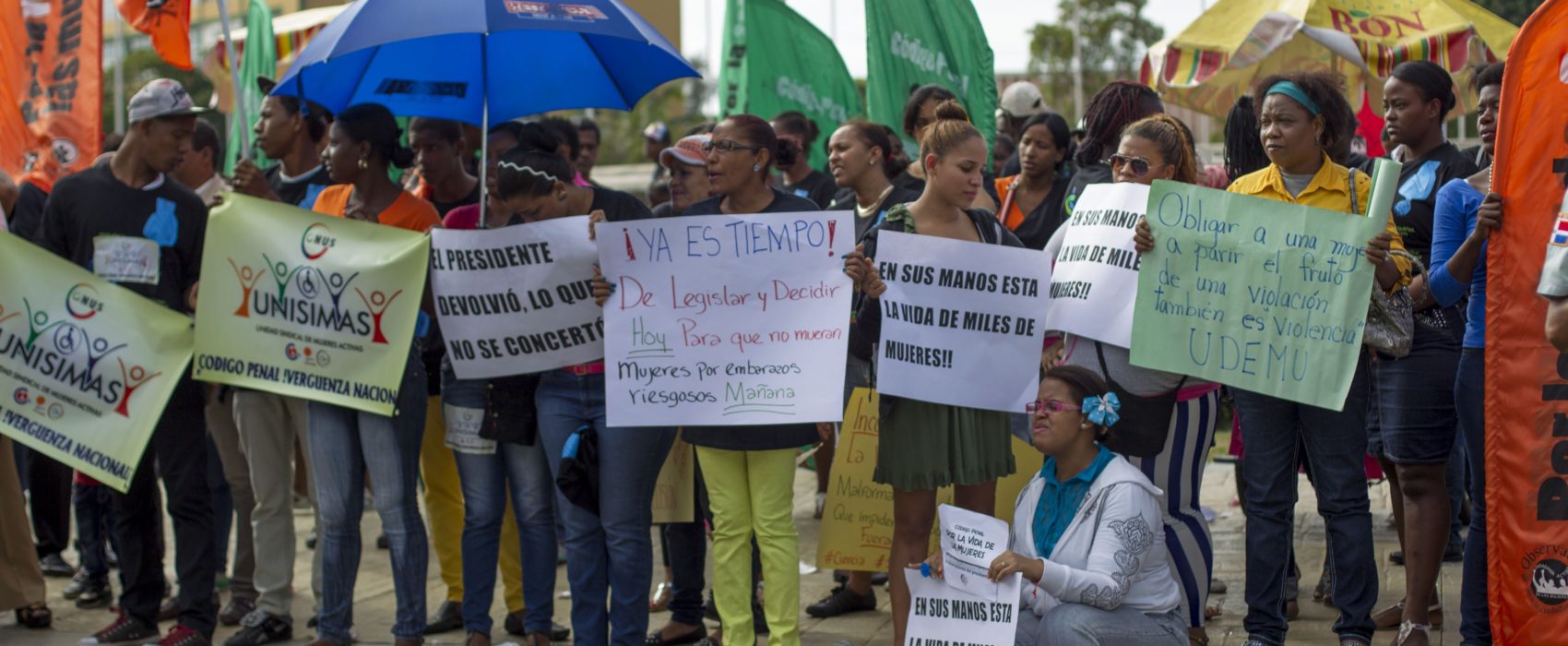 People hold signs during a pro-abortion demonstration in front of the National Congress in Santo Domingo, Dominican Republic, on December 16, 2014. The Dominican Medical College and the "Coalition for the rights and life of women", headed a demonstration demanding integrity, health and life of the women and calling to the respect of their decision on abortion and avoid the deaths in clandestine hospitals, according to local press.  AFP PHOTO/ERIKA SANTELICES        (Photo credit should read ERIKA SANTELICES/AFP/Getty Images)