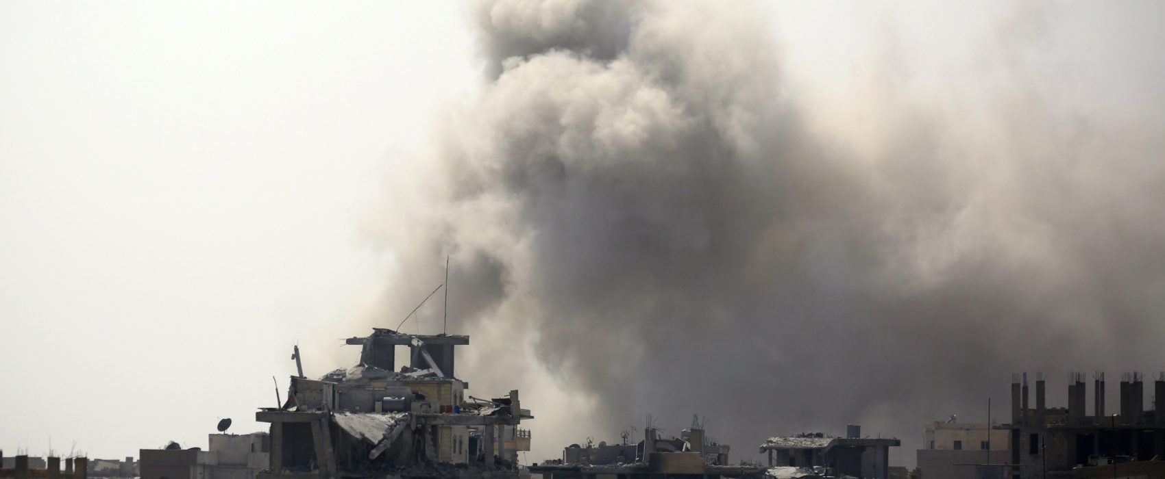Smoke rises from building in Raqa's eastern al-Sanaa neighbourhood, on the edge of the old city, on August 13, 2017, as Syrian Democratic Forces (SDF), a US backed Kurdish-Arab alliance, battle to retake the city from the Islamic State (IS) group.  / AFP PHOTO / Delil souleiman        (Photo credit should read DELIL SOULEIMAN/AFP/Getty Images)