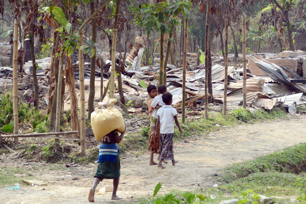 Local residents walk through burnt houses in Maungdaw in Myanmar's Rakhine State, which has a large Muslim Rohingya population, on Dec. 21, 2016. They claim soldiers from the country's armed forces burned a village in October. A number of Rohingya women there also claim to have been raped. However, some villagers dispute the claims - journalists hear first hand from Myanmar's Rohingya on gov't tour
©  Kyodo News /Getty Images