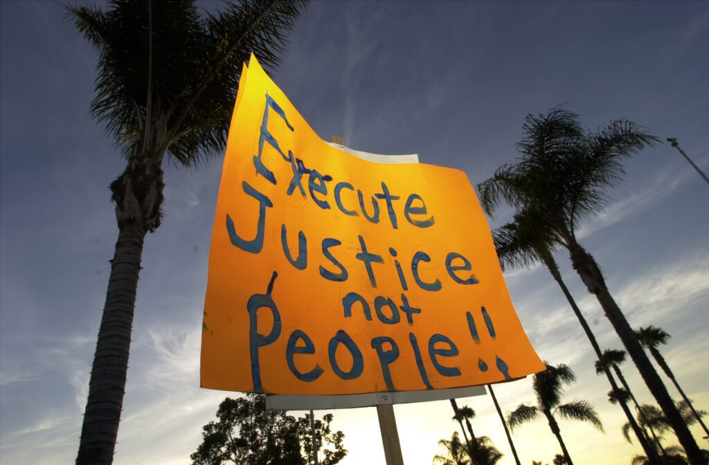 A sign reads Execute Justice not people
