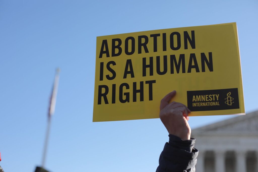 A sign is held that reads Abortion is a Human Right