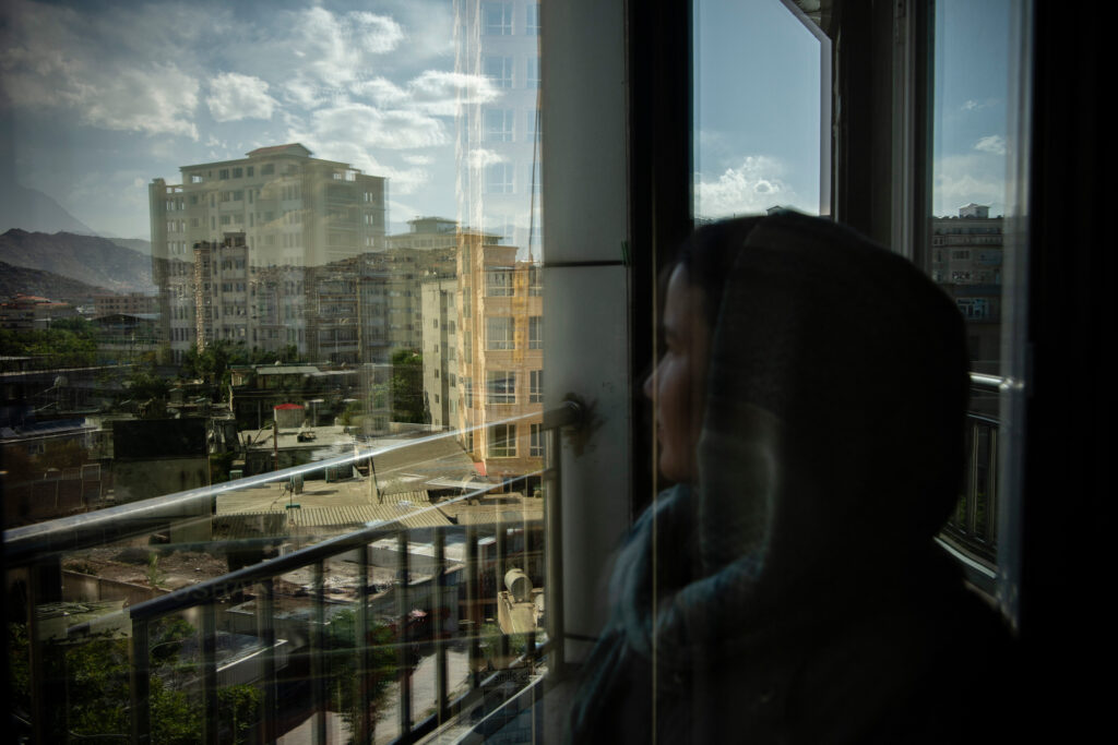 Woman looks out of the window in Taliban controlled Afghanistan