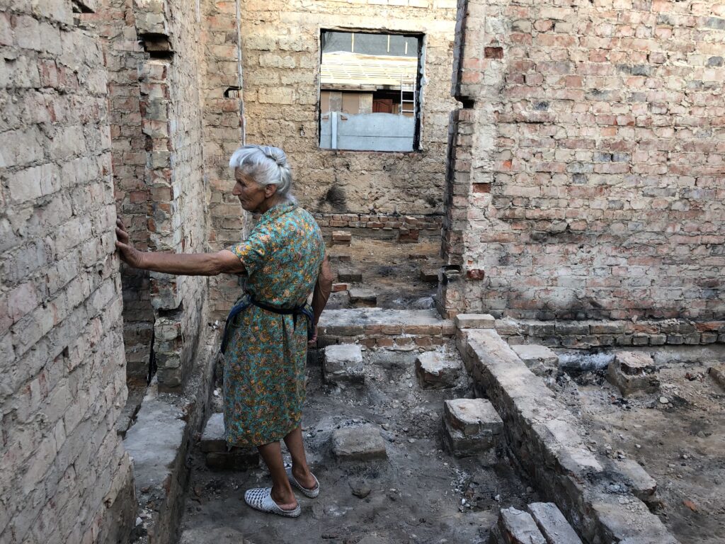 Hanna Selivon standing in her destroyed home in Chernihiv, Ukraine. July 2022.