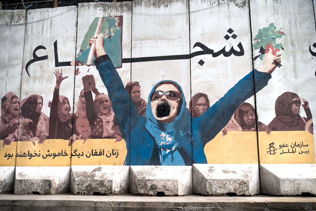 A wall mural of women with a writing "Afghan women will not be silent anymore" is depicted along a street in Kabul on January 10, 2023. (Photo by Wakil KOHSAR / AFP) (Photo by WAKIL KOHSAR/AFP via Getty Images)