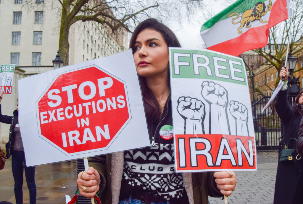 A protester holds 'Stop executions in Iran' and 'Free Iran' placards during the demonstration in London, on January 14, 2023. Demonstrators gathered outside Downing Street in protest against the death penalty and executions in Iran and in support of freedom for Iran.