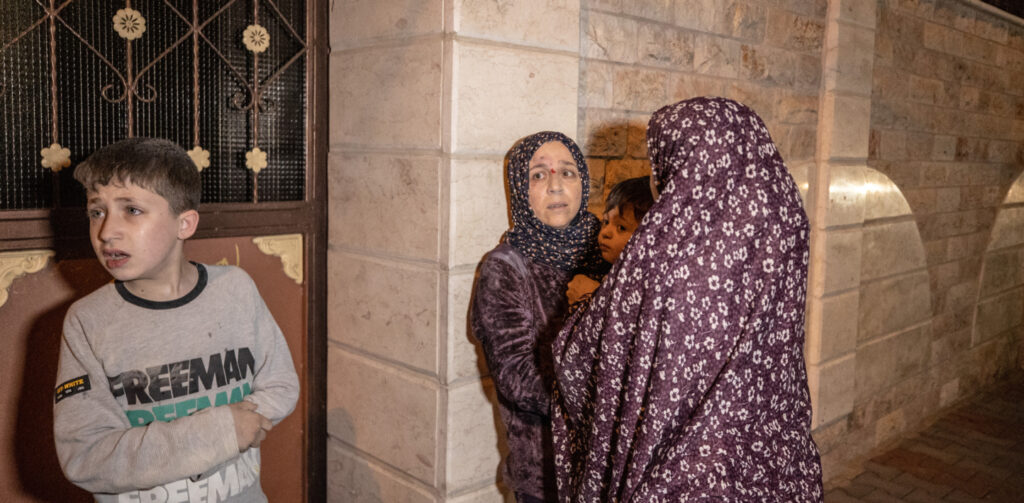 Two women and a child wait in a corridor in Palestine