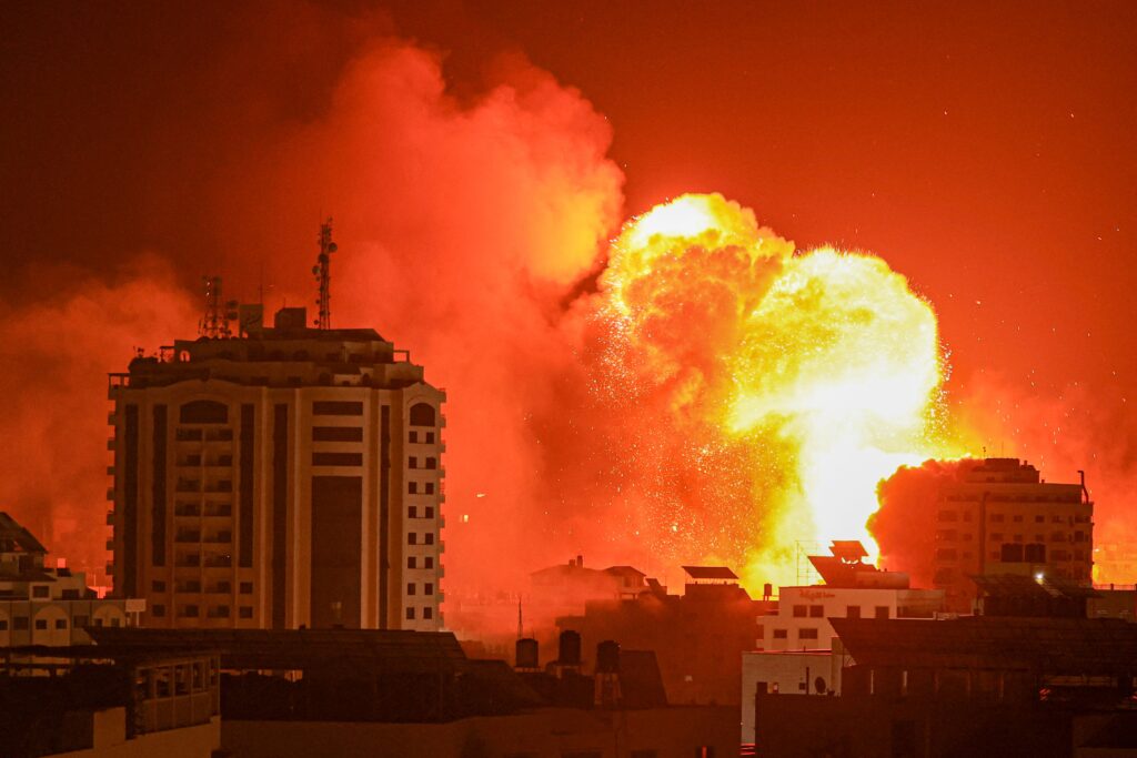 A fireball erupts from an Israeli airstrike in Gaza City on October 9, 2023. We call for an urgent ceasefire.